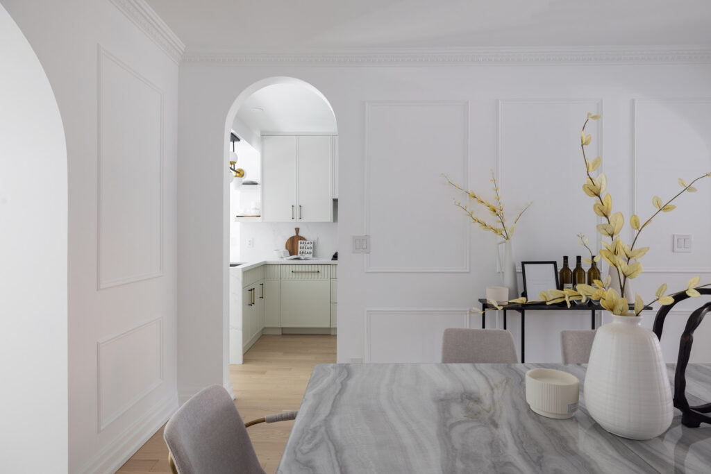 A modern, elegant interior featuring white plaster crown moulding, arched entryways, and contemporary furnishings.