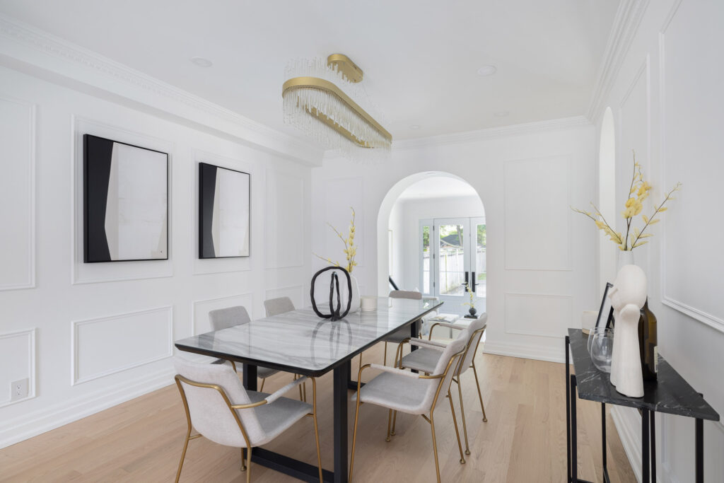A modern, elegant interior featuring white plaster crown moulding, arched entryways, and contemporary furnishings.