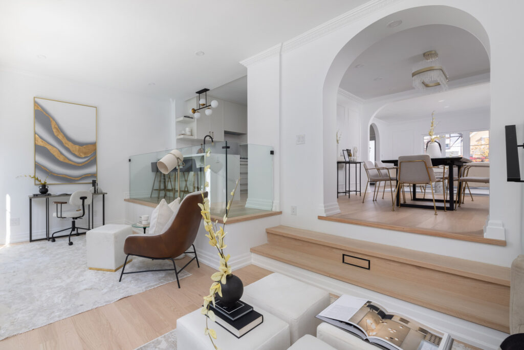 A modern, elegant interior featuring white plaster crown moulding, arched entryways, and contemporary furnishings.