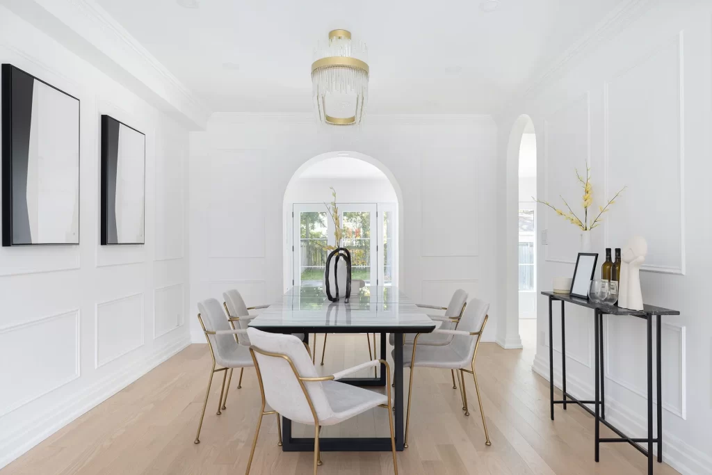 A modern, elegant interior featuring white plaster crown moulding, arched entryways, and contemporary furnishings.