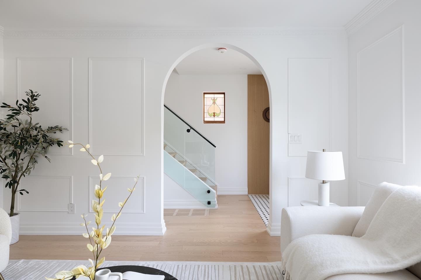 Best Ceiling Molding Ideas for Every Room A modern, elegant interior featuring white plaster crown moulding, arched entryways, and contemporary furnishings.